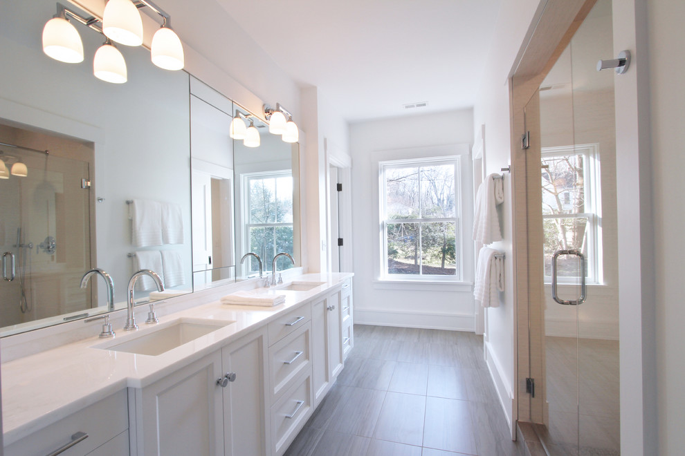 Example of a large trendy master white tile and porcelain tile porcelain tile alcove shower design in New York with shaker cabinets, white cabinets, a two-piece toilet, white walls, a drop-in sink and marble countertops