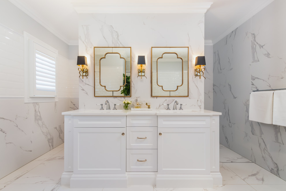 Exemple d'une salle de bain chic avec un placard avec porte à panneau encastré, des portes de placard blanches, un carrelage blanc, un lavabo encastré, un sol blanc, un plan de toilette blanc, meuble double vasque et meuble-lavabo encastré.