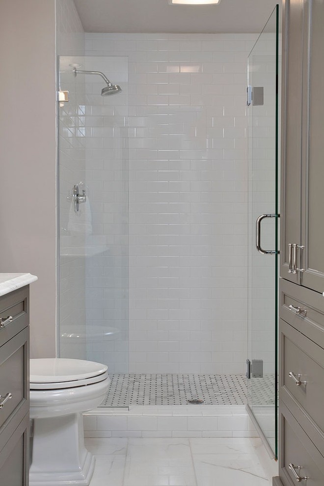 Exemple d'une salle de bain principale chic de taille moyenne avec un placard à porte shaker, des portes de placard grises, un plan de toilette en quartz, une douche ouverte, un carrelage blanc, un carrelage métro, un sol en marbre, un mur gris et un lavabo encastré.