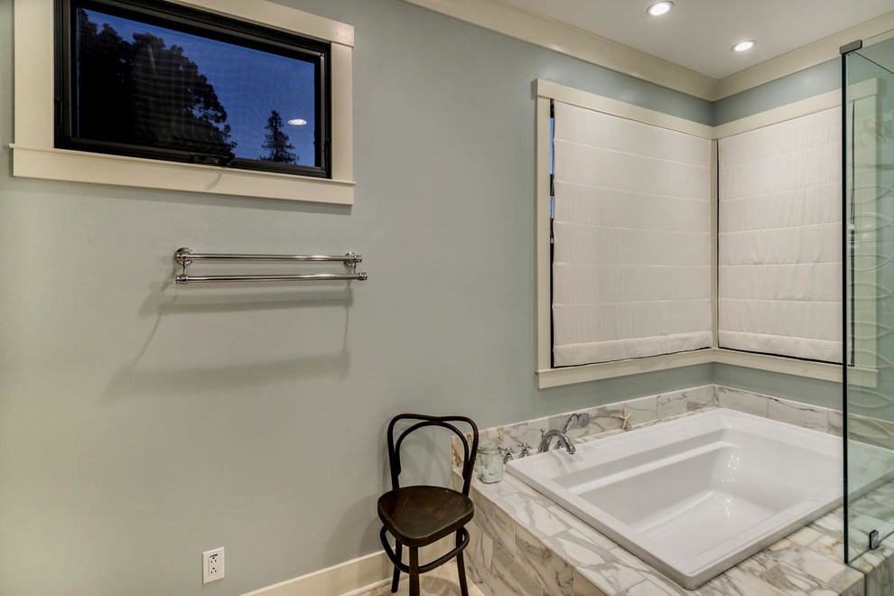 Idée de décoration pour une salle de bain principale design en bois foncé de taille moyenne avec un placard à porte shaker, une baignoire posée, une douche d'angle, un carrelage blanc, un carrelage de pierre, un mur gris, un sol en calcaire, un lavabo encastré et un plan de toilette en marbre.