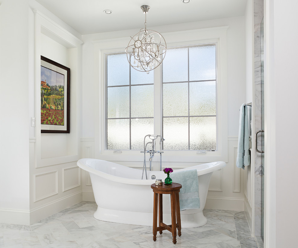 Idee per una stanza da bagno chic di medie dimensioni con vasca freestanding, pareti bianche, pavimento in marmo e pavimento bianco