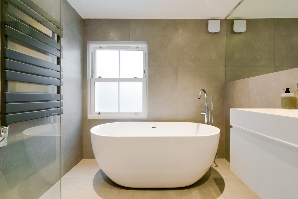 Design ideas for a small contemporary family bathroom in London with flat-panel cabinets, white cabinets, a freestanding bath, a walk-in shower, a wall mounted toilet, beige tiles, porcelain tiles, beige walls, porcelain flooring, a wall-mounted sink, beige floors and an open shower.