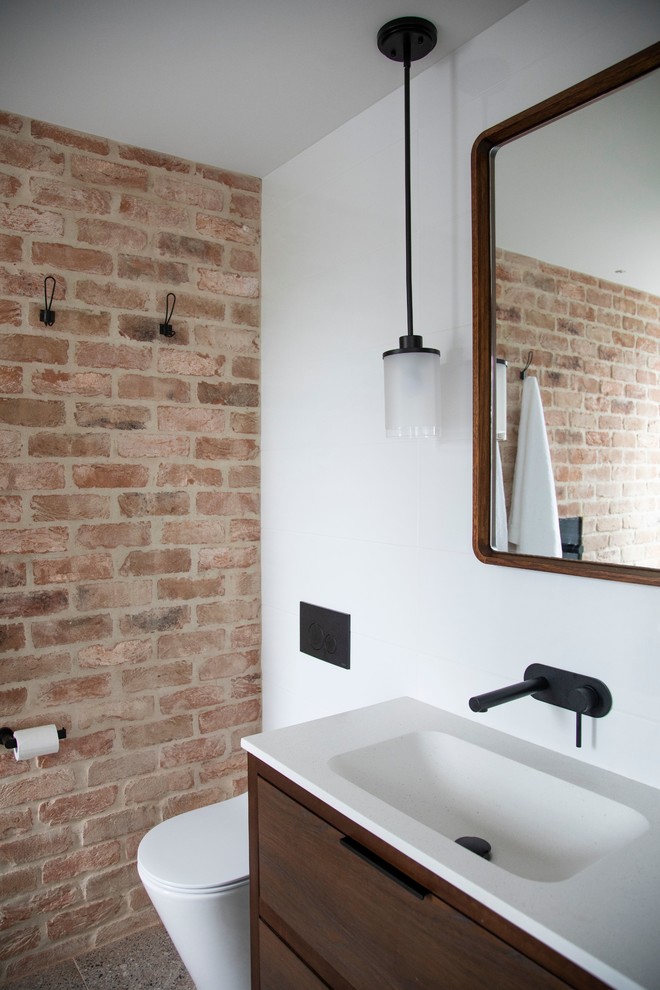 На фото: ванная комната в современном стиле с плоскими фасадами, темными деревянными фасадами, инсталляцией, белыми стенами, консольной раковиной и серым полом с