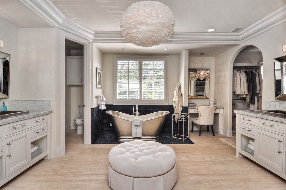 Diseño de cuarto de baño clásico renovado con armarios con paneles empotrados, puertas de armario blancas, bañera exenta, paredes beige y lavabo encastrado