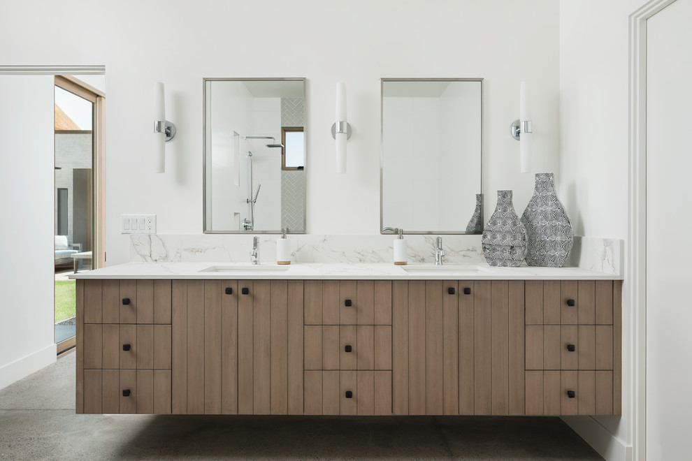 Example of a southwest white tile and porcelain tile concrete floor and gray floor bathroom design in Phoenix with flat-panel cabinets, brown cabinets, a two-piece toilet, white walls, a drop-in sink and quartz countertops