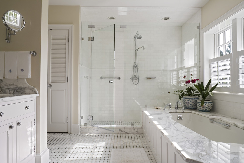 Идея дизайна: большая главная ванная комната в классическом стиле с врезной раковиной, фасадами с утопленной филенкой, белыми фасадами, мраморной столешницей, полновстраиваемой ванной, каменной плиткой, бежевыми стенами и мраморным полом