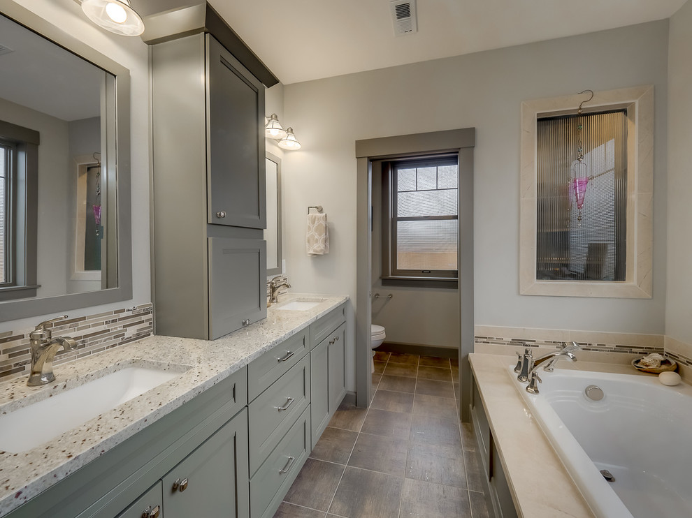 Inspiration for a large transitional master gray tile, multicolored tile and glass tile porcelain tile and brown floor bathroom remodel in Portland with recessed-panel cabinets, gray cabinets, gray walls, an undermount sink, granite countertops, a two-piece toilet and white countertops
