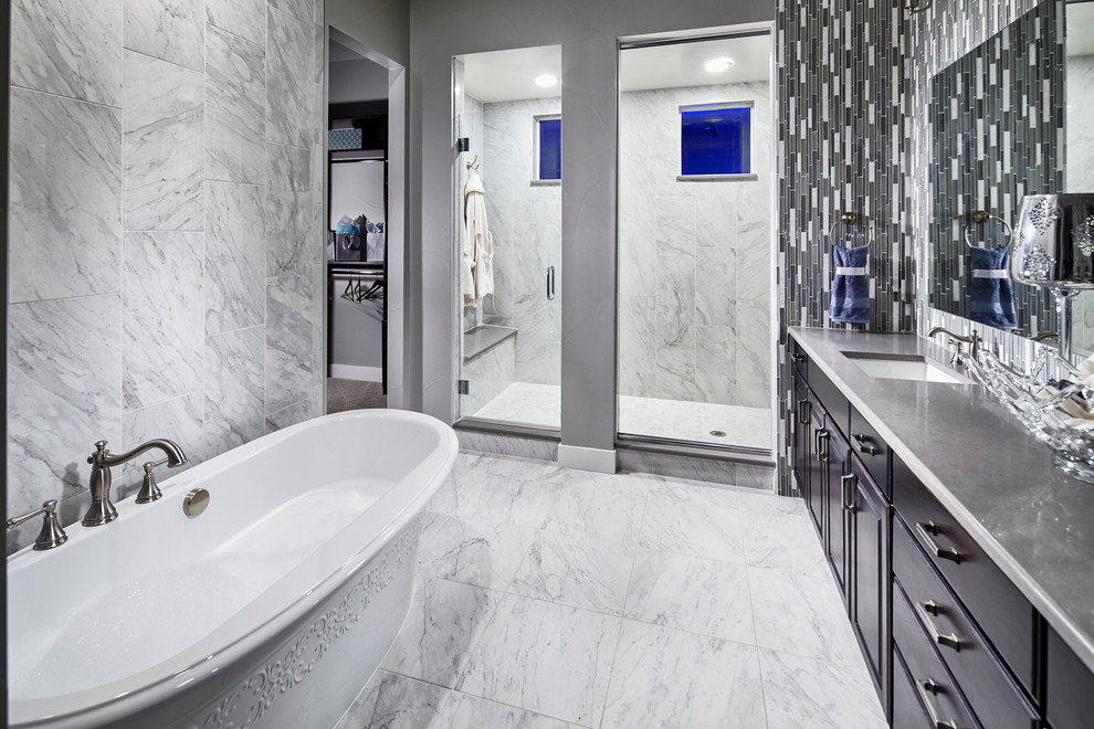 Inspiration for a large modern ensuite bathroom in Other with raised-panel cabinets, black cabinets, a freestanding bath, an alcove shower, black and white tiles, grey tiles, matchstick tiles, grey walls, marble flooring, a submerged sink, solid surface worktops and grey floors.