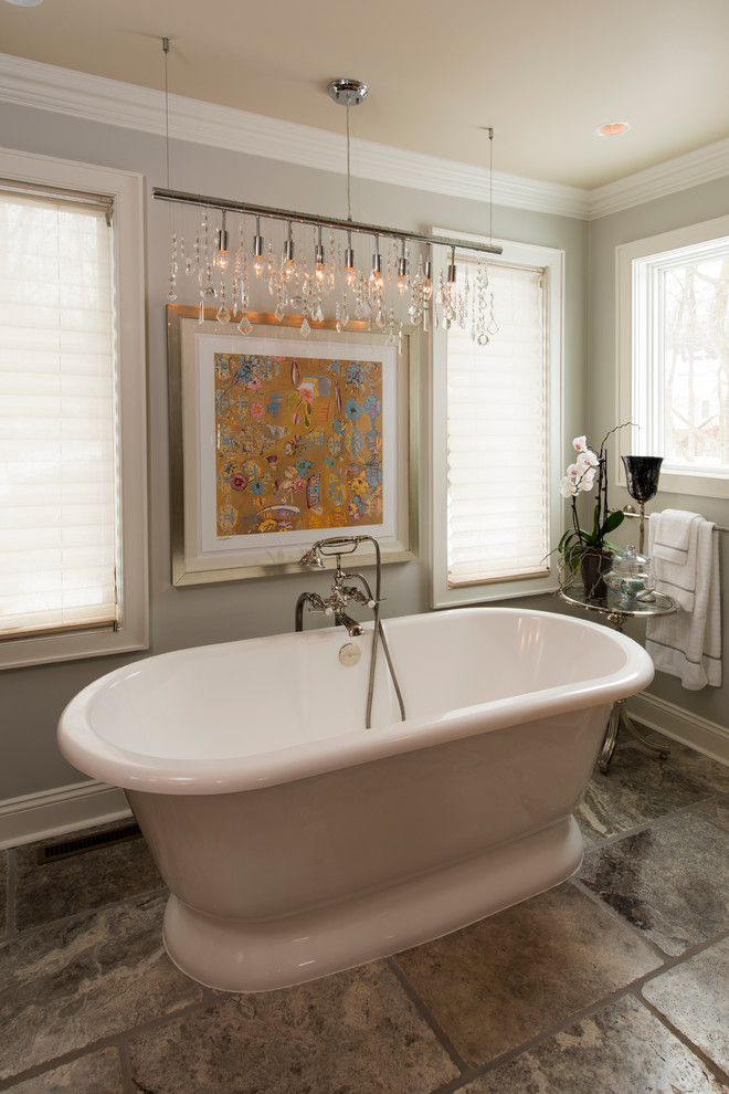Modelo de cuarto de baño principal clásico renovado de tamaño medio con bañera exenta, paredes grises, suelo de travertino y suelo marrón
