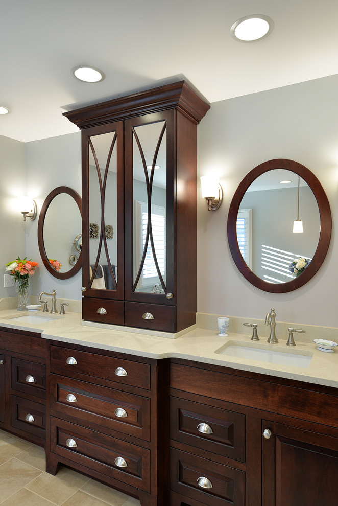 Ejemplo de cuarto de baño clásico grande con lavabo bajoencimera, armarios con paneles con relieve, puertas de armario de madera en tonos medios y paredes grises
