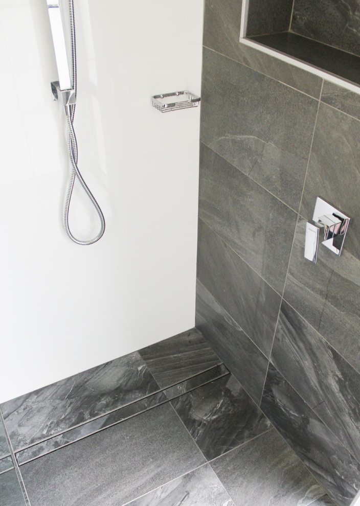 Exempel på ett stort modernt en-suite badrum, med luckor med upphöjd panel, svarta skåp, en öppen dusch, svart kakel, porslinskakel, vita väggar, klinkergolv i porslin, ett fristående handfat, bänkskiva i akrylsten, svart golv och med dusch som är öppen