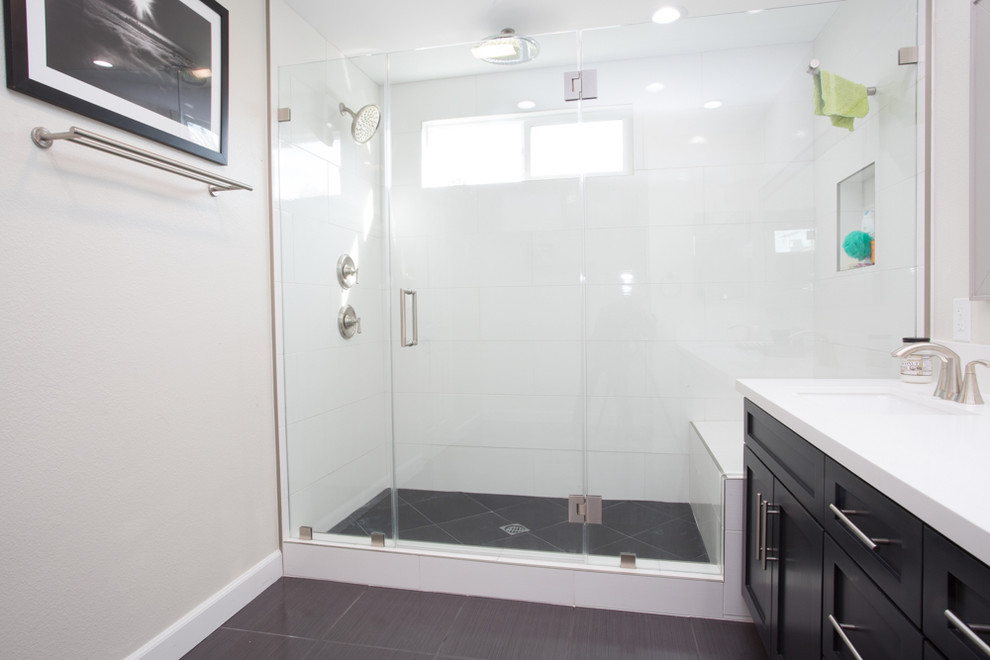 This is an example of a medium sized contemporary shower room bathroom in Los Angeles with recessed-panel cabinets, black cabinets, an alcove shower, white tiles, white walls, ceramic flooring, a submerged sink, quartz worktops, black floors, a hinged door and white worktops.