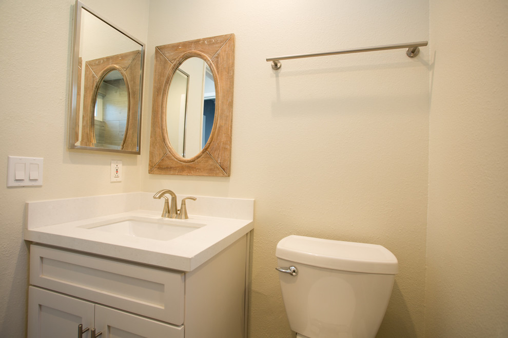 Aménagement d'une salle de bain contemporaine de taille moyenne avec un placard avec porte à panneau encastré, des portes de placard grises, WC séparés, un carrelage beige, des carreaux de céramique, un mur beige, un sol en carrelage de porcelaine, un lavabo encastré, un plan de toilette en quartz, un sol marron, une cabine de douche à porte battante et un plan de toilette blanc.