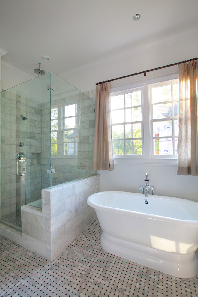 Foto de cuarto de baño principal clásico con lavabo bajoencimera, puertas de armario blancas, encimera de mármol, bañera exenta y paredes blancas