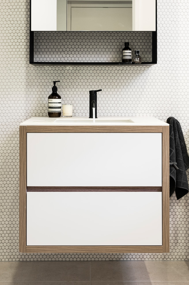 メルボルンにある小さなコンテンポラリースタイルのおしゃれな浴室 (濃色木目調キャビネット、置き型浴槽、白いタイル、白い壁、一体型シンク、グレーの床、白い洗面カウンター) の写真