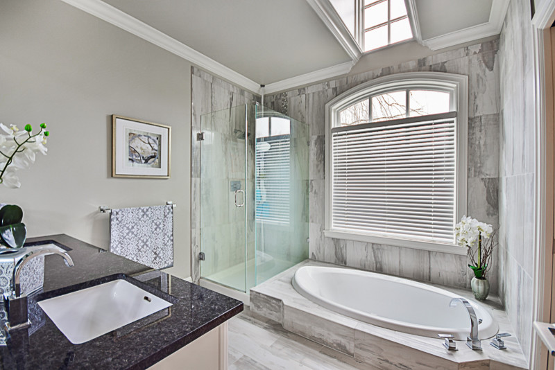 Klassisk inredning av ett en-suite badrum, med ett platsbyggt badkar, en hörndusch, porslinskakel, grå väggar, klinkergolv i porslin, ett undermonterad handfat, granitbänkskiva, dusch med gångjärnsdörr, möbel-liknande och vita skåp