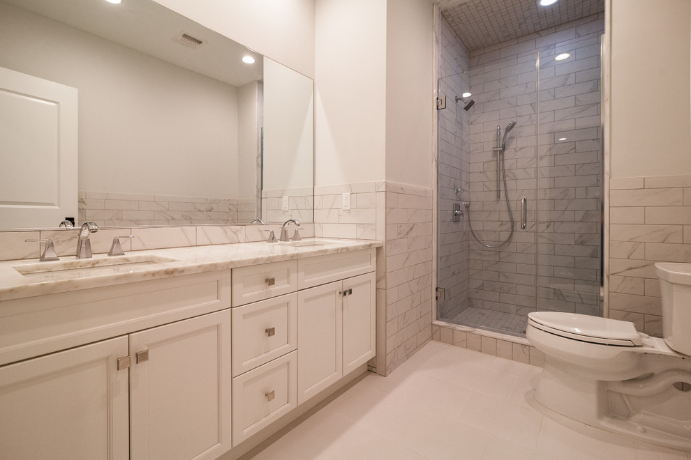ニューヨークにあるトランジショナルスタイルのおしゃれな浴室 (家具調キャビネット、白いキャビネット、分離型トイレ、白いタイル、磁器タイル、磁器タイルの床、オーバーカウンターシンク、クオーツストーンの洗面台) の写真