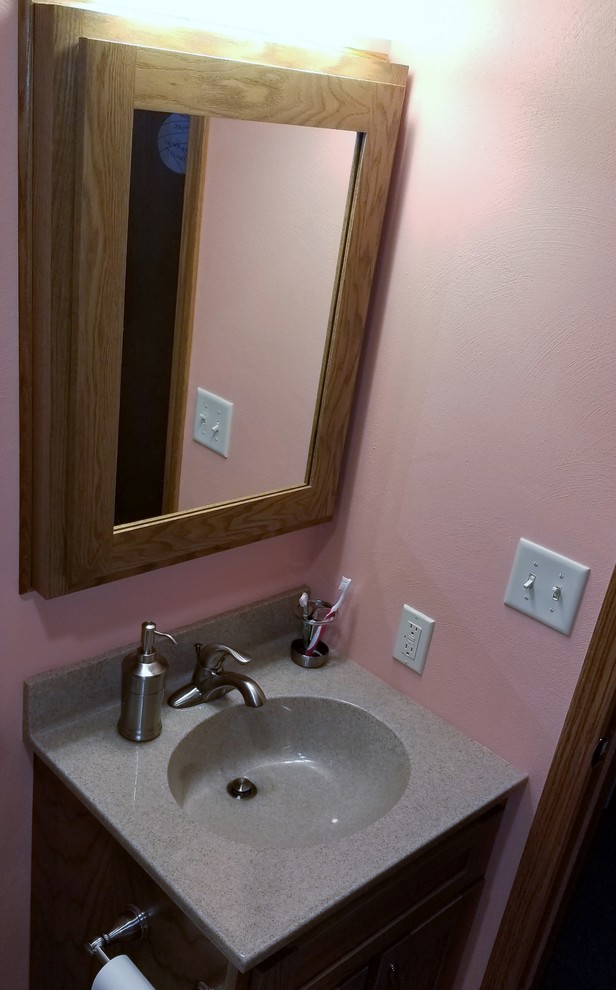 Aménagement d'une salle de bain craftsman pour enfant avec un placard à porte shaker et un mur rose.