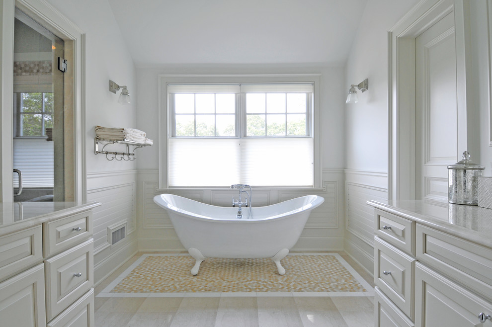 Idée de décoration pour une douche en alcôve principale marine avec un placard avec porte à panneau surélevé, des portes de placard blanches, une baignoire sur pieds, un carrelage beige et un mur blanc.