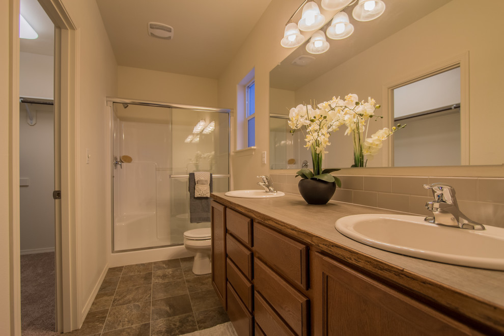 Amerikansk inredning av ett mellanstort en-suite badrum, med en dusch i en alkov, vit kakel, tunnelbanekakel, vinylgolv, ett nedsänkt handfat och laminatbänkskiva