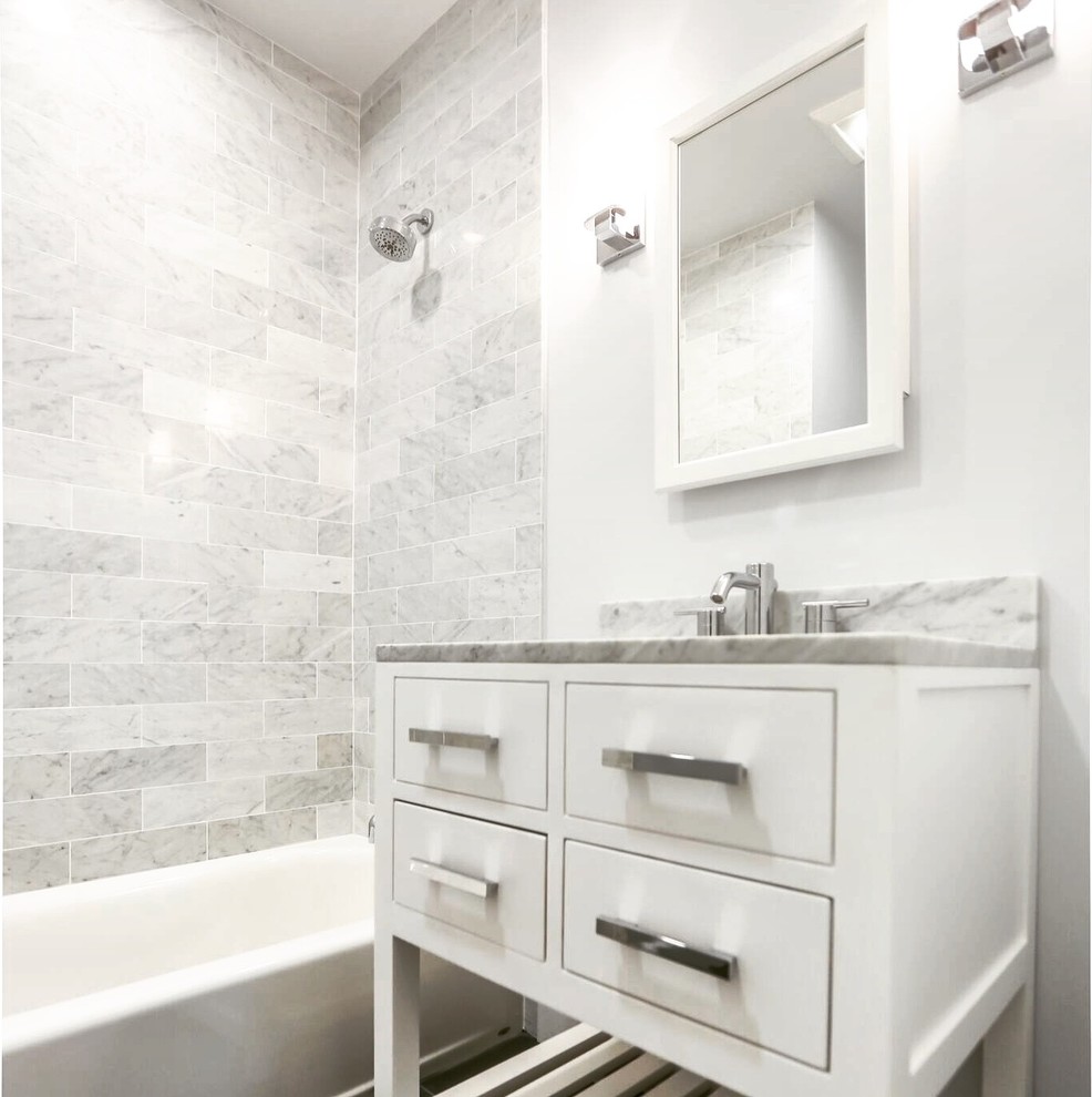 Ispirazione per una piccola stanza da bagno con doccia moderna con ante lisce, ante bianche, vasca da incasso, WC monopezzo, piastrelle grigie, piastrelle in ceramica, pareti grigie, pavimento in ardesia, lavabo sottopiano e top in marmo