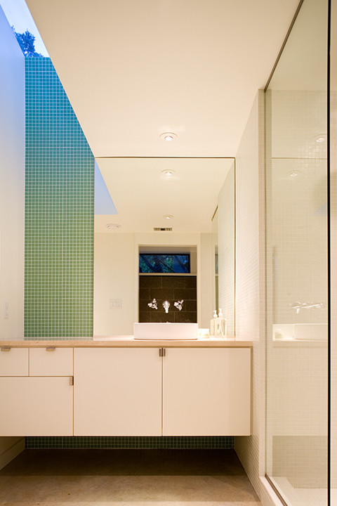 Immagine di una stanza da bagno padronale minimalista di medie dimensioni con ante lisce, ante bianche, piastrelle a mosaico, pareti bianche, lavabo a bacinella, top in quarzite, doccia alcova, piastrelle verdi e pavimento in cemento