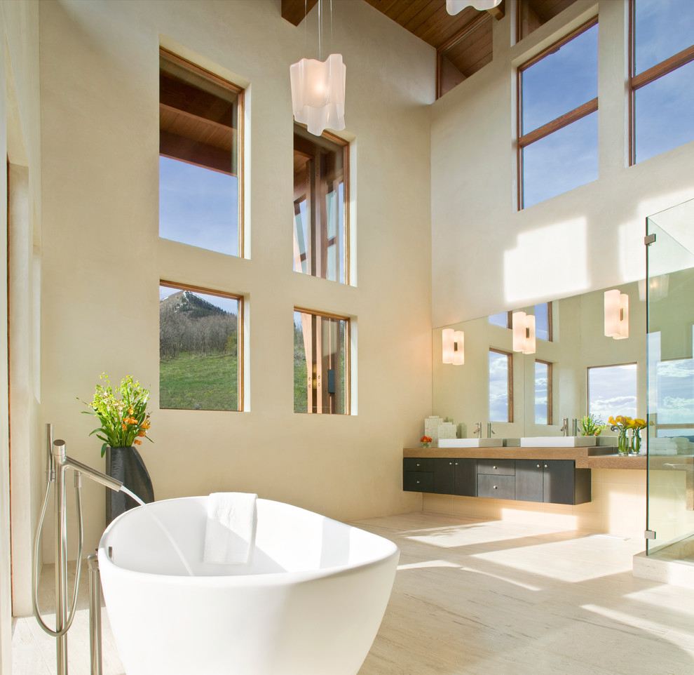 Пример оригинального дизайна: большая главная ванная комната в современном стиле с отдельно стоящей ванной, настольной раковиной, плоскими фасадами, черными фасадами, угловым душем, бежевой плиткой и бежевыми стенами