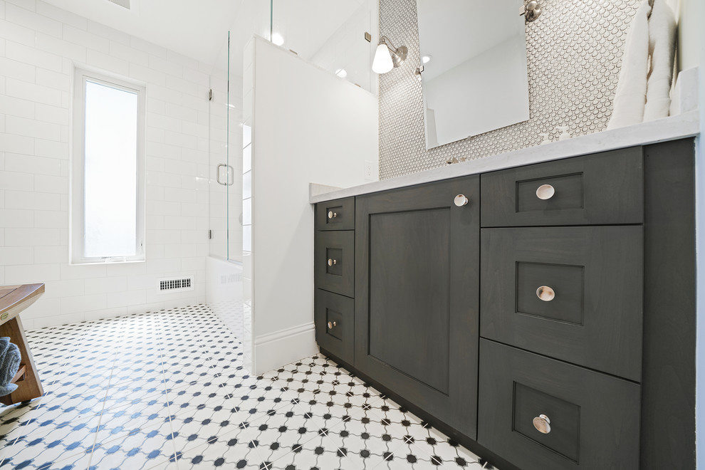 Пример оригинального дизайна: большая ванная комната в стиле кантри с фасадами в стиле шейкер, черными фасадами, угловой ванной, душем над ванной, белой плиткой, плиткой кабанчик, серыми стенами, полом из керамогранита, душевой кабиной, врезной раковиной, мраморной столешницей, разноцветным полом, душем с распашными дверями и белой столешницей