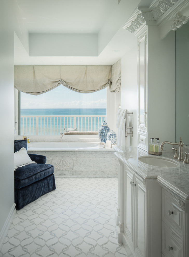 Источник вдохновения для домашнего уюта: большая главная ванная комната в морском стиле с фасадами с выступающей филенкой, белыми фасадами, полновстраиваемой ванной, белыми стенами, врезной раковиной, мраморной столешницей и белым полом