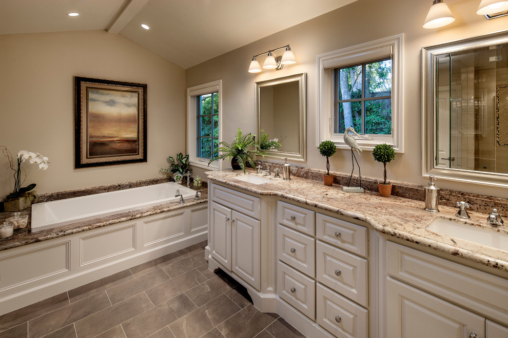 Bild på ett stort vintage en-suite badrum, med skåp i shakerstil, vita skåp, ett badkar i en alkov, en öppen dusch, beige kakel, stenkakel, beige väggar, klinkergolv i keramik, ett undermonterad handfat och granitbänkskiva