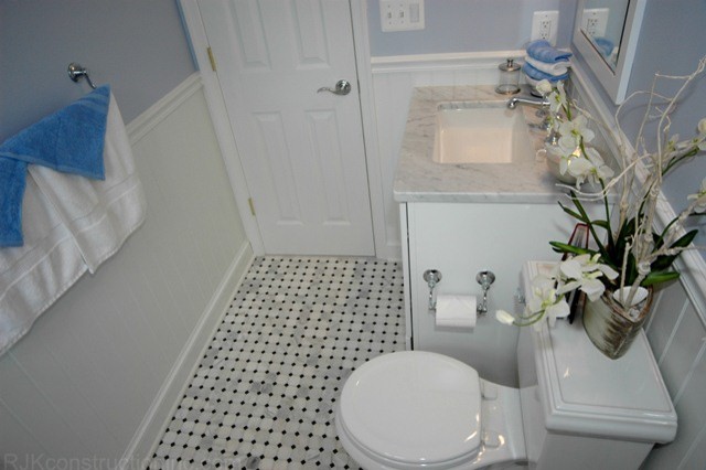 Idées déco pour une salle de bain principale classique de taille moyenne avec des portes de placard blanches, un plan de toilette en marbre, une baignoire posée, un combiné douche/baignoire, un carrelage blanc, un carrelage métro, un mur bleu et un sol en marbre.