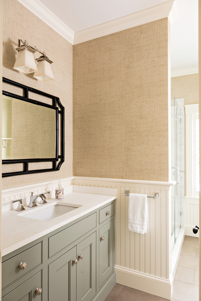 Exempel på ett mellanstort klassiskt en-suite badrum, med luckor med infälld panel, ett fristående badkar, en dusch i en alkov, travertin golv, ett undermonterad handfat, bänkskiva i akrylsten, porslinskakel, dusch med gångjärnsdörr, grå skåp, beige väggar och beiget golv