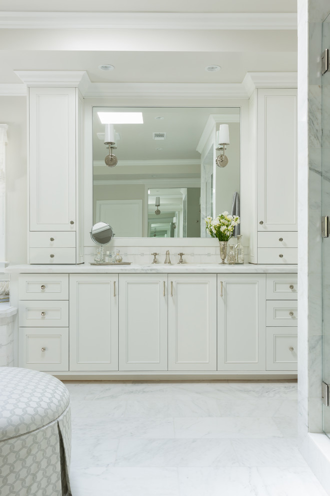 На фото: большая главная ванная комната в классическом стиле с фасадами с декоративным кантом, белыми фасадами, мраморной столешницей, угловой ванной, душем в нише, унитазом-моноблоком, белой плиткой, плиткой мозаикой и мраморным полом с
