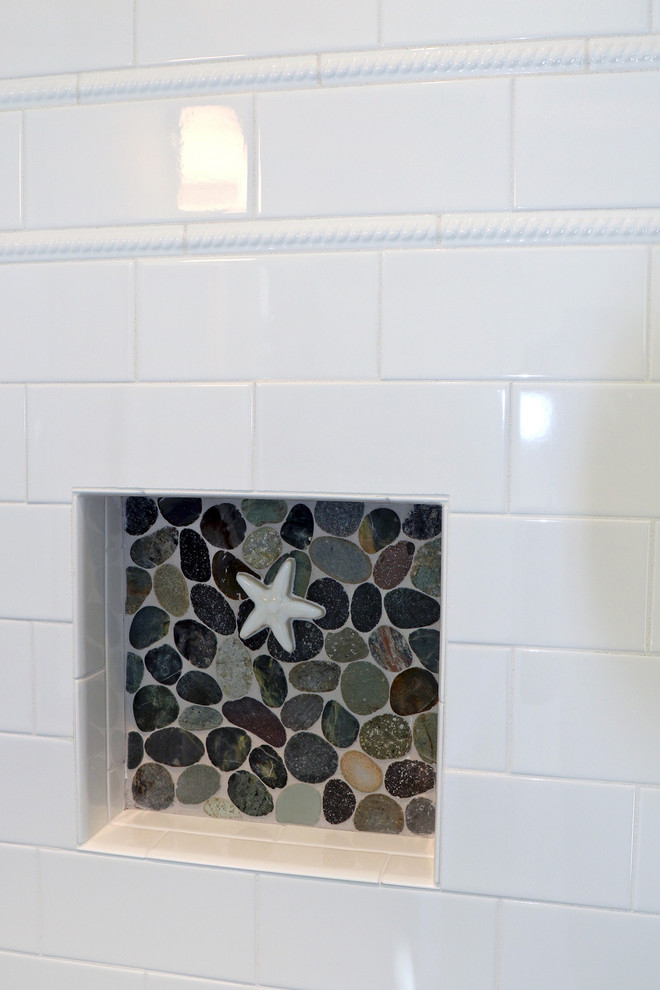 Modelo de cuarto de baño costero con baldosas y/o azulejos blancos, suelo de baldosas tipo guijarro, paredes blancas y suelo de baldosas tipo guijarro