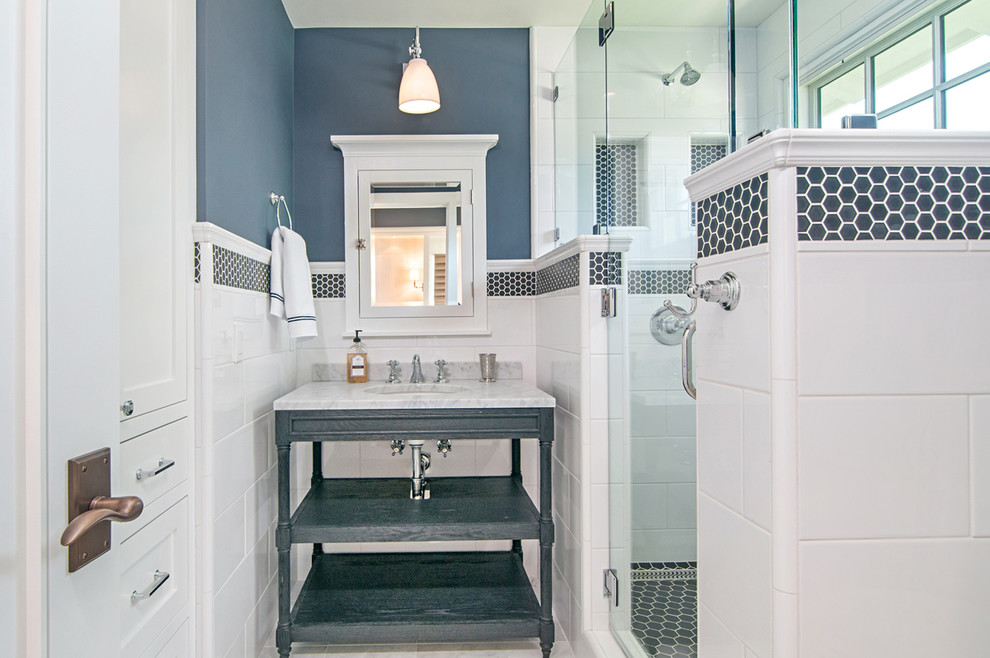 Exemple d'une salle de bain chic de taille moyenne avec des portes de placard blanches, une douche d'angle, un carrelage blanc, des carreaux de céramique, un mur bleu, un sol en carrelage de porcelaine, un lavabo posé et un plan de toilette en marbre.