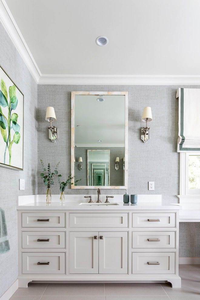 ロサンゼルスにあるトランジショナルスタイルのおしゃれな浴室 (シェーカースタイル扉のキャビネット、白いキャビネット、グレーの壁、アンダーカウンター洗面器、ベージュの床、白い洗面カウンター) の写真