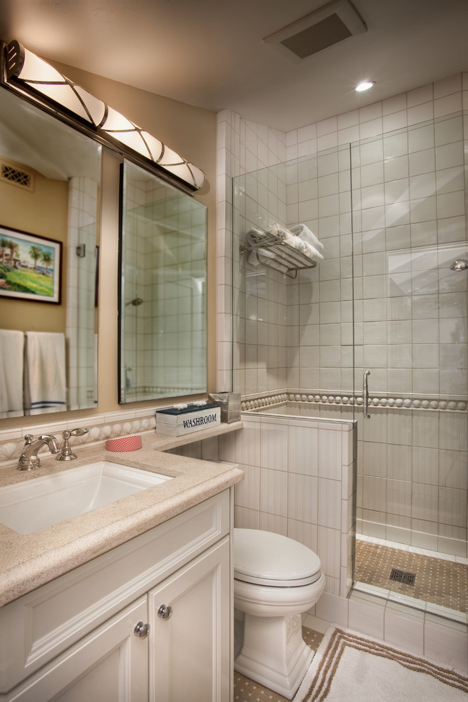 Modelo de cuarto de baño marinero con puertas de armario blancas, ducha a ras de suelo, baldosas y/o azulejos blancos y paredes beige