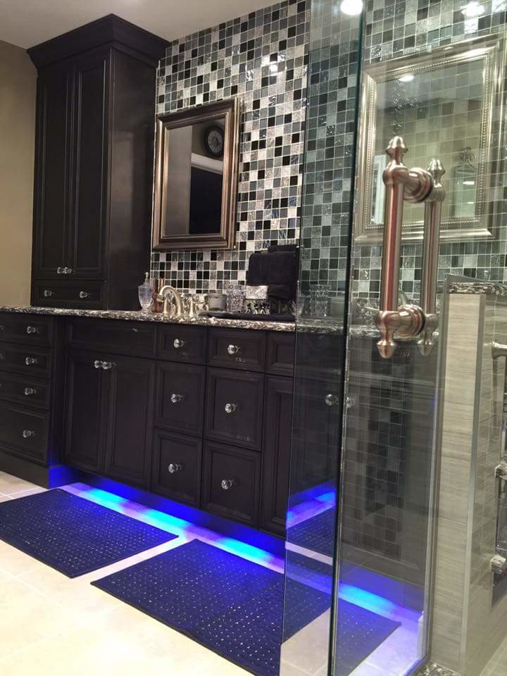 Medium sized contemporary ensuite bathroom in Miami with recessed-panel cabinets, a corner shower, beige tiles, black tiles, grey tiles, beige walls, ceramic flooring, a submerged sink, engineered stone worktops, dark wood cabinets, a two-piece toilet and mosaic tiles.