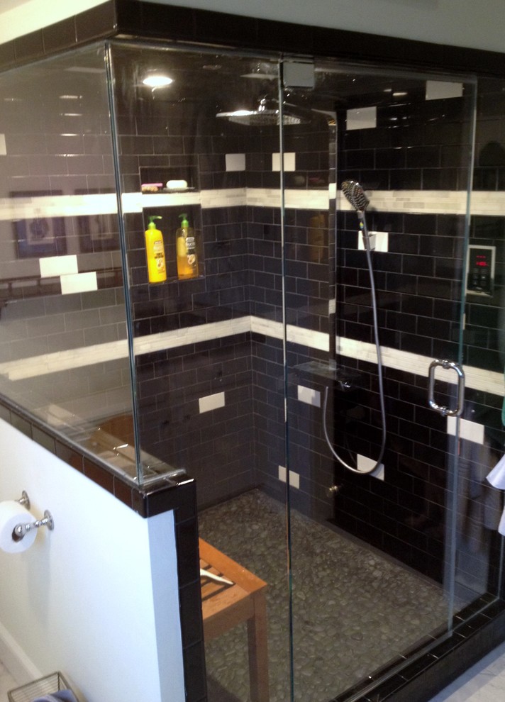 Exemple d'une grande douche en alcôve principale tendance avec un carrelage noir, un carrelage métro, un mur blanc et un sol en galet.