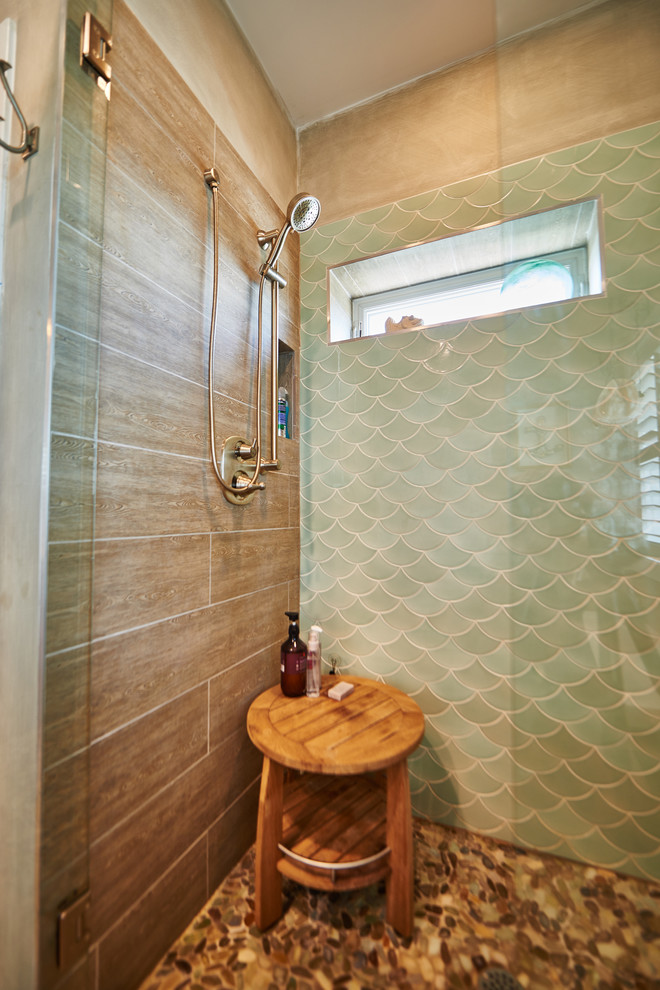 Bild på ett stort maritimt vit vitt en-suite badrum, med luckor med lamellpanel, blå skåp, ett platsbyggt badkar, en dusch i en alkov, grön kakel, porslinskakel, beige väggar, klinkergolv i småsten, ett undermonterad handfat, brunt golv och dusch med gångjärnsdörr