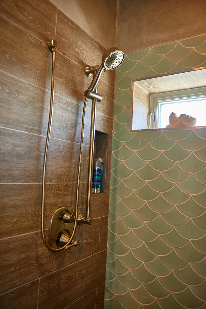 Cette photo montre une grande douche en alcôve principale bord de mer avec un placard à porte persienne, des portes de placard bleues, une baignoire posée, un carrelage vert, des carreaux de porcelaine, un mur beige, un sol en galet, un lavabo encastré, un sol marron, une cabine de douche à porte battante et un plan de toilette blanc.