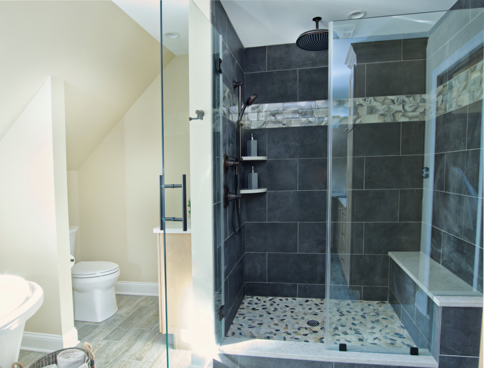 Klassisk inredning av ett stort beige beige en-suite badrum, med luckor med infälld panel, bruna skåp, ett fristående badkar, en dusch i en alkov, en toalettstol med separat cisternkåpa, grå kakel, skifferkakel, beige väggar, klinkergolv i keramik, ett undermonterad handfat, bänkskiva i kvarts, grått golv och dusch med gångjärnsdörr