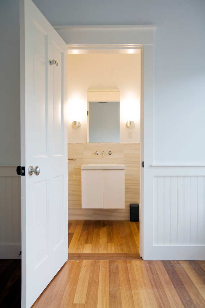 Ispirazione per una stanza da bagno tradizionale di medie dimensioni con ante lisce, ante bianche, pareti bianche e pavimento in legno massello medio