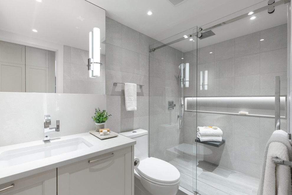 Inspiration for a small traditional ensuite bathroom in Vancouver with shaker cabinets, white cabinets, white tiles, white walls, a built-in sink, brown floors, white worktops, a single sink and a built in vanity unit.