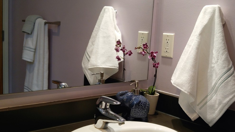 Immagine di una piccola stanza da bagno per bambini minimalista con ante lisce, ante in legno chiaro, vasca da incasso, WC monopezzo, pareti viola, pavimento con piastrelle in ceramica, lavabo da incasso e top in laminato