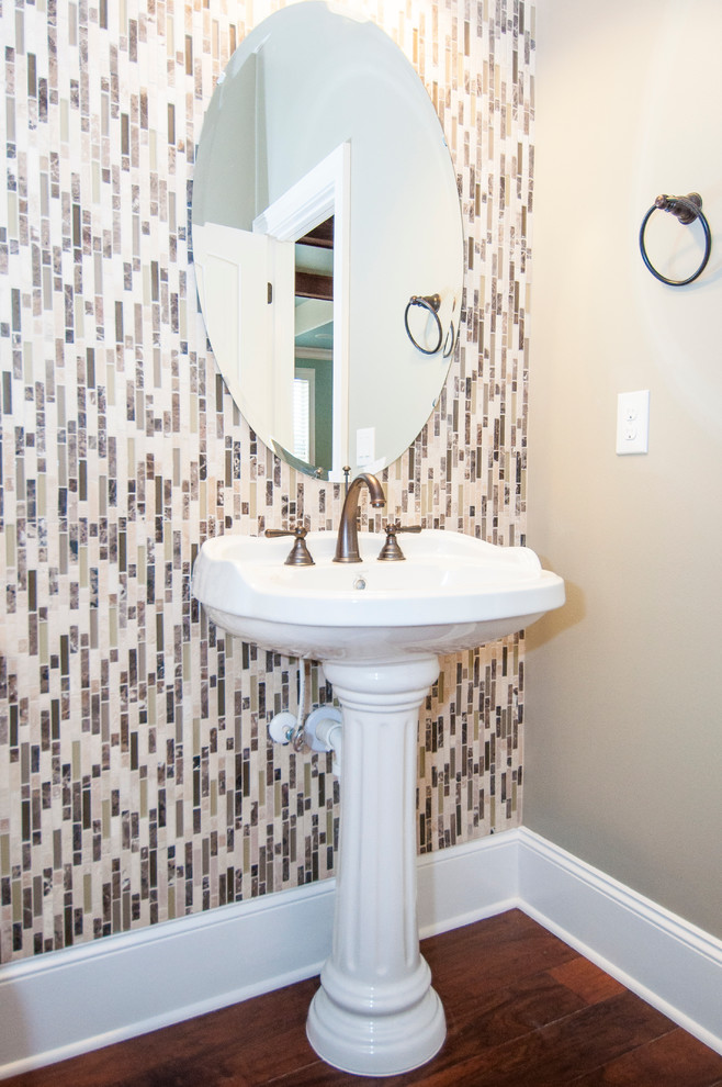 Cette image montre une salle de bain minimaliste de taille moyenne avec un lavabo de ferme, un carrelage multicolore, un carrelage en pâte de verre, un mur gris et un sol en bois brun.