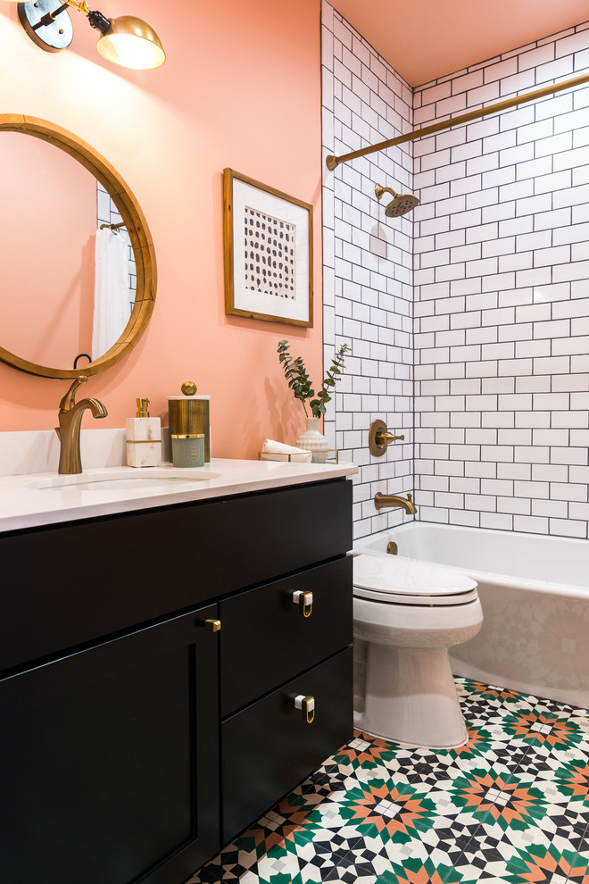 Idée de décoration pour une salle d'eau design de taille moyenne avec un placard avec porte à panneau encastré, des portes de placard noires, un combiné douche/baignoire, un carrelage blanc, un carrelage métro, un mur rose, un lavabo encastré, un sol multicolore, une cabine de douche avec un rideau, un plan de toilette blanc, une baignoire en alcôve, WC séparés, un plan de toilette en surface solide et un sol en carrelage de céramique.