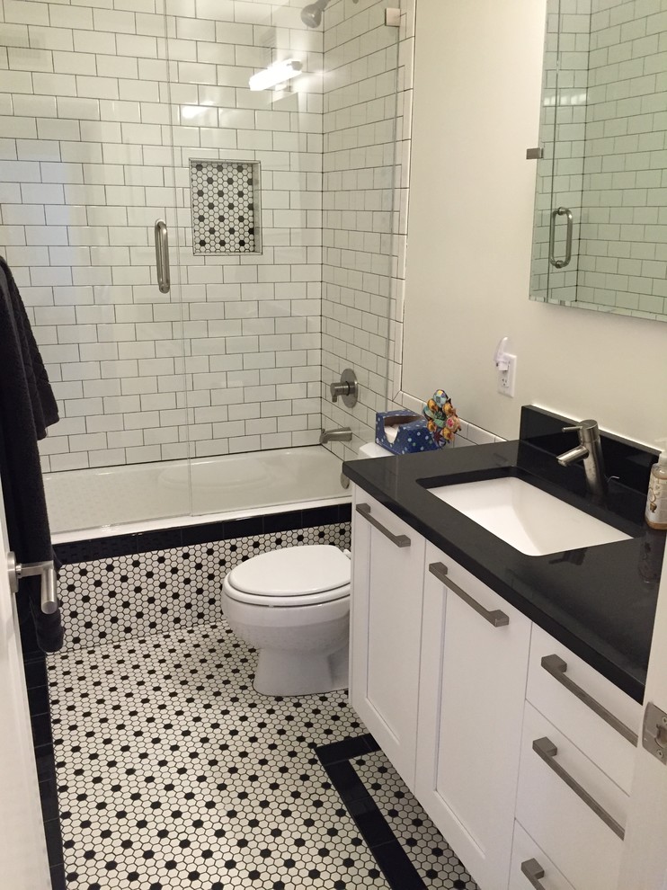 Idéer för små vintage svart badrum med dusch, med skåp i shakerstil, vita skåp, ett badkar i en alkov, en dusch/badkar-kombination, en toalettstol med hel cisternkåpa, vit kakel, tunnelbanekakel, grå väggar, klinkergolv i keramik, ett undermonterad handfat, bänkskiva i akrylsten, vitt golv och dusch med gångjärnsdörr