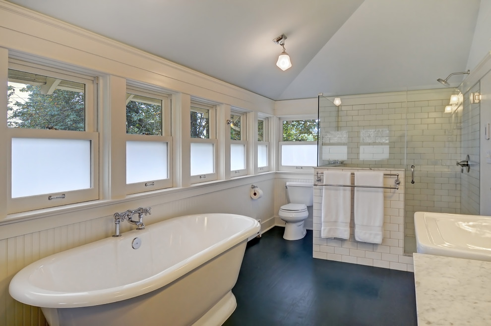 Inspiration for a medium sized traditional ensuite bathroom in Seattle with shaker cabinets, marble worktops, a freestanding bath, a corner shower, a two-piece toilet, white tiles, porcelain tiles, a pedestal sink, white walls and dark hardwood flooring.