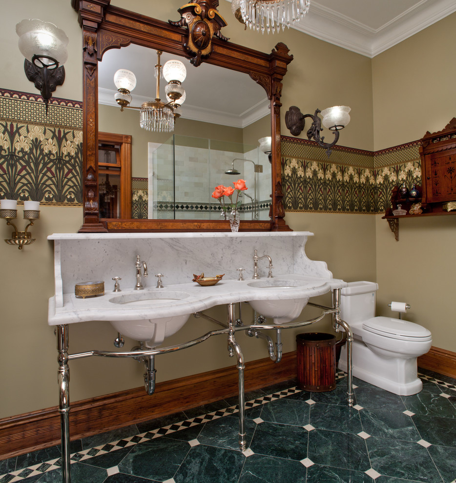 Modelo de cuarto de baño clásico con sanitario de una pieza, paredes beige, lavabo bajoencimera y suelo verde
